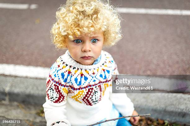 portrait of starring blond little boy wearing patterned knit pullover - boy curly blonde stock pictures, royalty-free photos & images