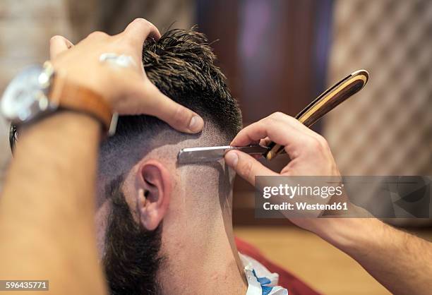 barber shaving head of a customer - half shaved hair stock pictures, royalty-free photos & images