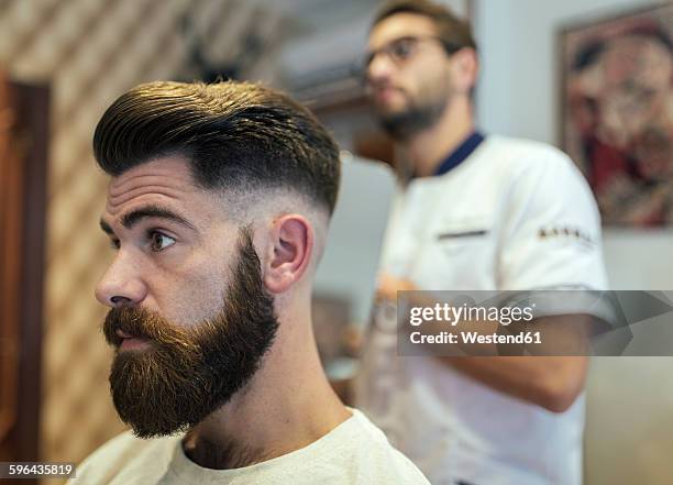 barber and customer in a barber shop - half shaved hair stock pictures, royalty-free photos & images