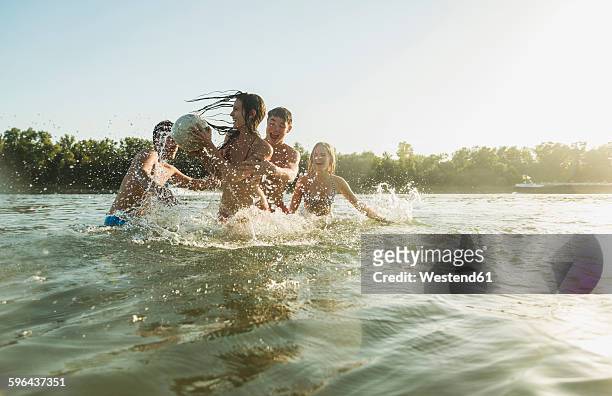 happy friends with ball in water - river bathing stock pictures, royalty-free photos & images