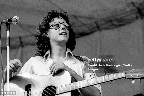 American Folk music musician Arlo Guthrie plays guitar as he performs during the Schaefer Music Festival at Central Park's Wollman Rink, New York,...