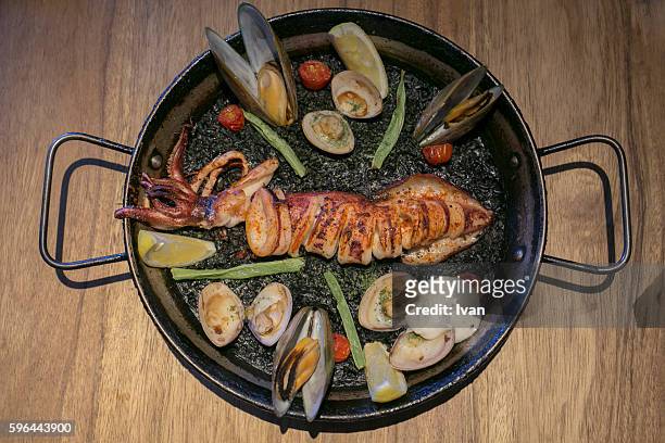 aerial view of spainish seafood paella, black risotto with roast seafood and dark cuttlefish sauce - denia stock pictures, royalty-free photos & images
