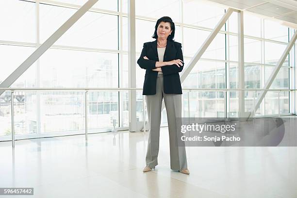 portrait of businesswoman in office building - mujeres de mediana edad fotografías e imágenes de stock
