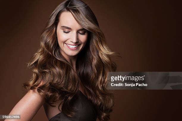 studio portrait of young woman with long brown hair - human hair stockfoto's en -beelden
