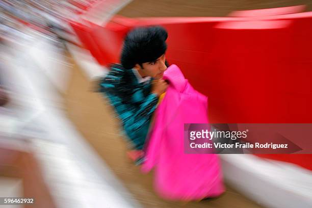 Assistant bullfighter runs behind the barrier during the Santiago bullfighting fair in the northern Spanish town of Santander.