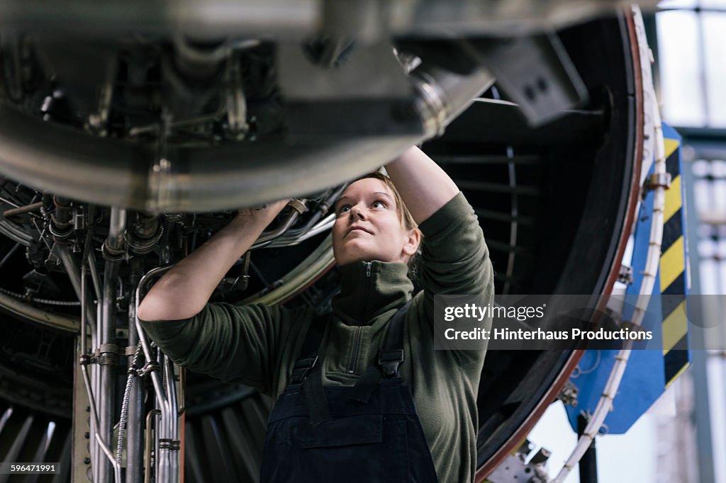 Female engineer working on jet engine