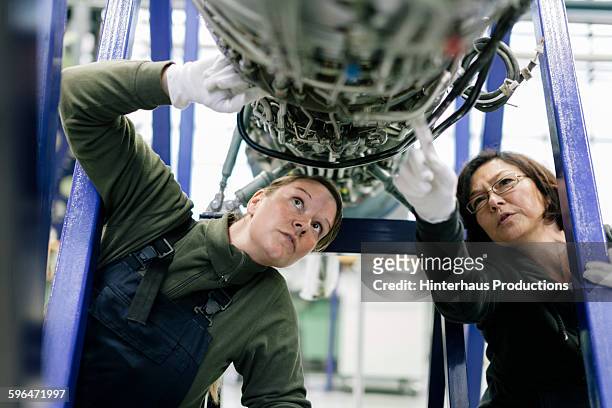 female mechanics examine an aircraft engine. - aviation worker stockfoto's en -beelden
