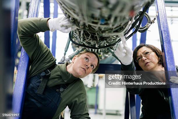 female mechanics examine an aircraft engine. - aerospace stock pictures, royalty-free photos & images