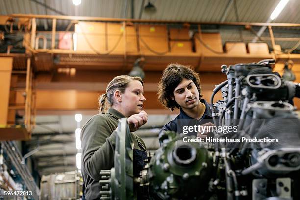 two mechanics are working on an engine - maschinenteil stock-fotos und bilder