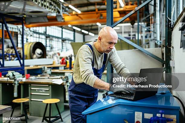 aircraft mechanic is working on computer - industriegebäude stock-fotos und bilder