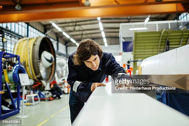 male aircraft mechanic inside an aircraft hangar - aeroplane parts stock pictures, royalty-free photos & images