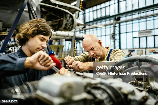 mechanics are working on an engine. - jet engine stock pictures, royalty-free photos & images