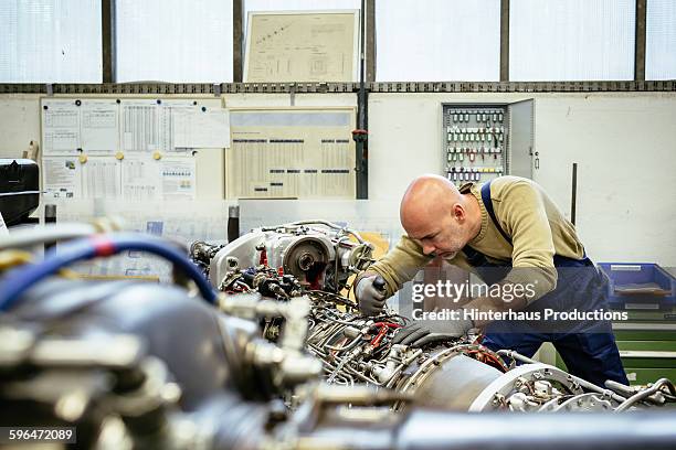 male mechanic working on an engine - machinery imagens e fotografias de stock