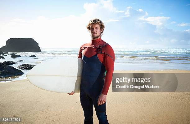 portrait of surfer on beach. - wetsuit stock pictures, royalty-free photos & images