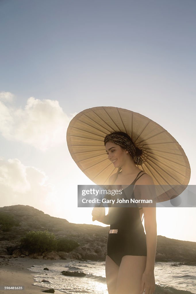 Woman protects herself from sun with parasol.