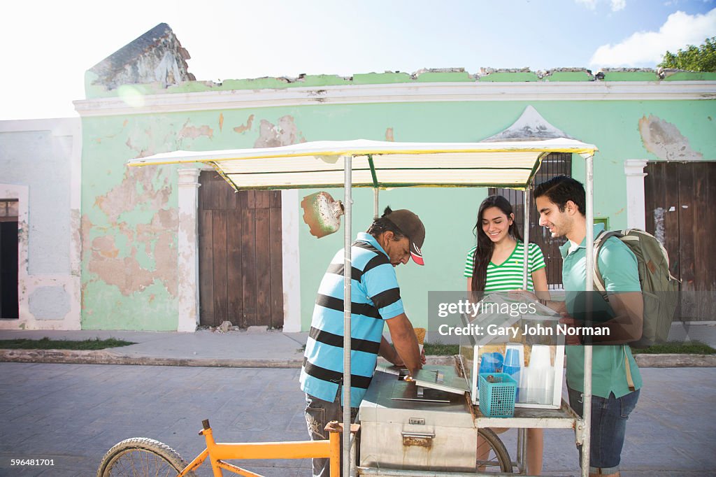 Couple buy an ice-cream from street vendor.