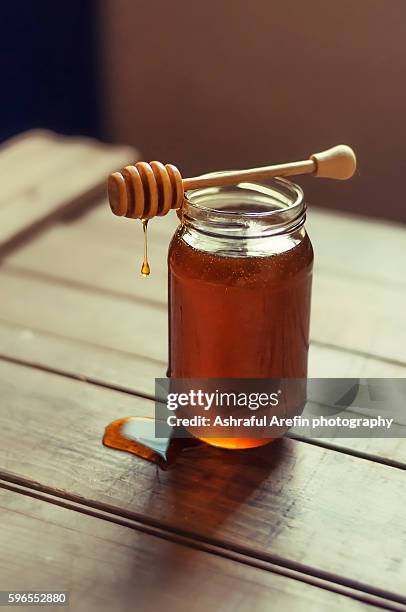 dripping honey from honey dipper and jar of honey - mel - fotografias e filmes do acervo