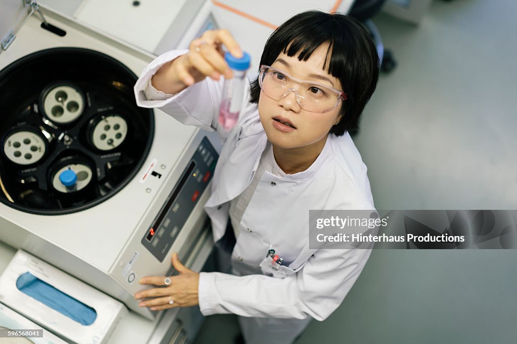 Asian scientist taking a look at a flask