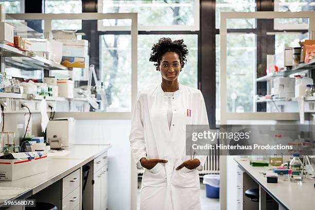 portrait of a black female scientist - bata de laboratorio fotografías e imágenes de stock