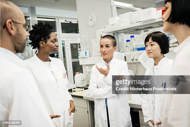 a group of scientists is standing in a laboratory - scientifique blouse blanche photos et images de collection