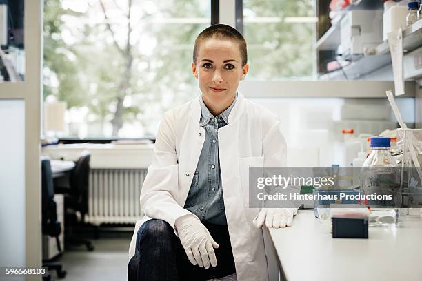 potrait of a female scientist sitting - scientist clean suit stock pictures, royalty-free photos & images