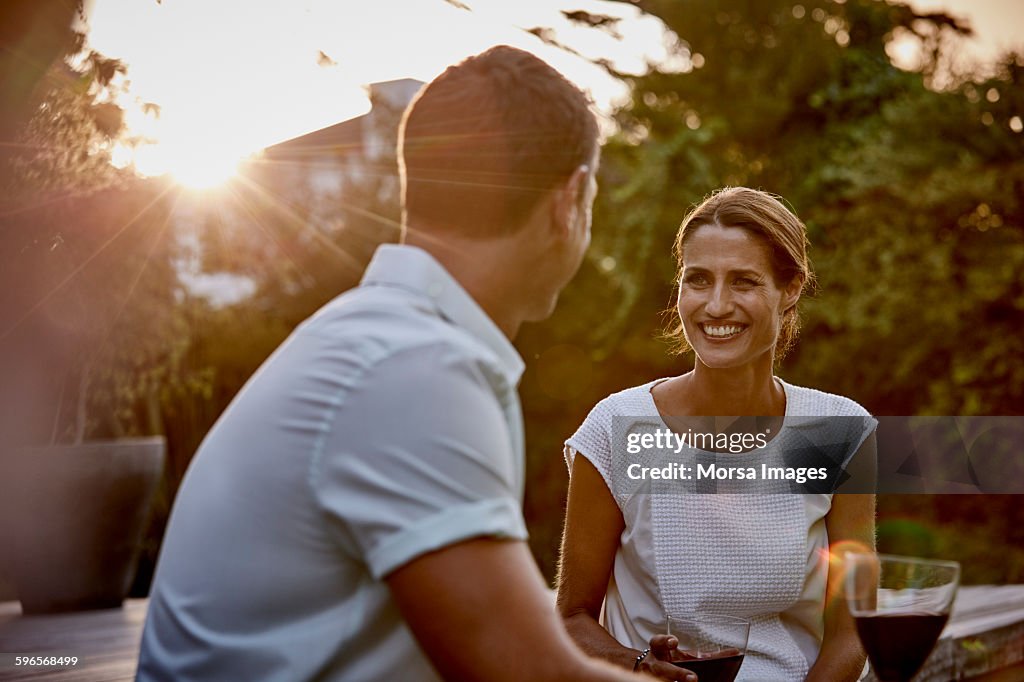 Couple having wine on floorboard