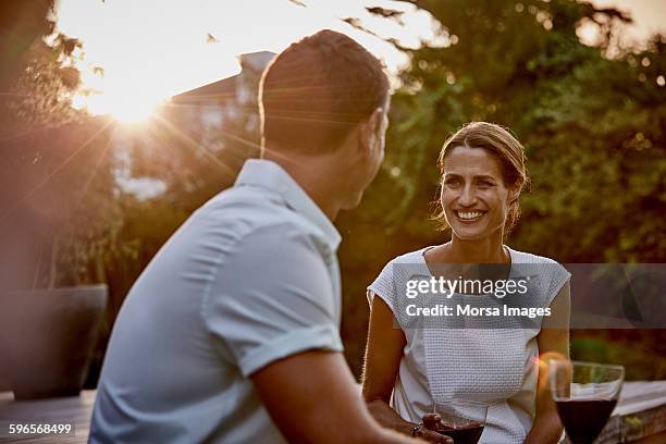 couple having wine on floorboard - sun flare couple stock pictures, royalty-free photos & images