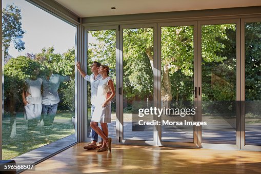 Loving couple looking through glass window Loving couple looking through glass window