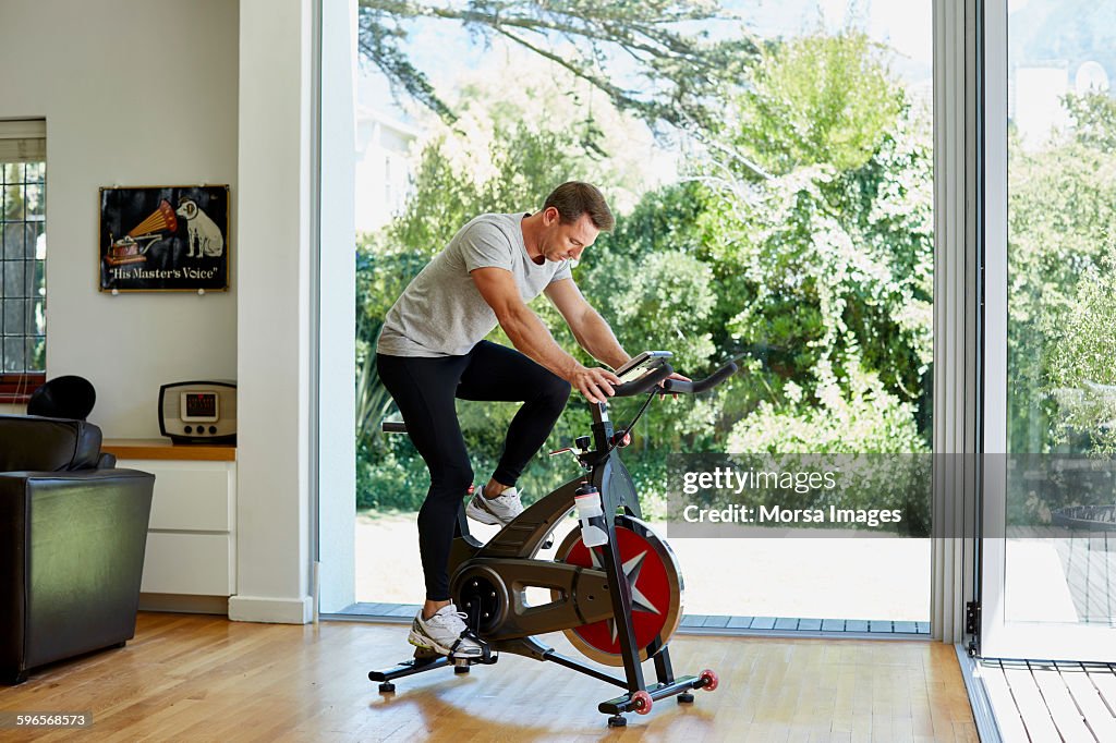 Hombre haciendo ejercicio en bicicleta estática en casa