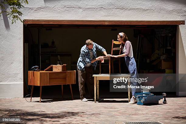 couple polishing chair outside house - woman cleaning for man stock pictures, royalty-free photos & images