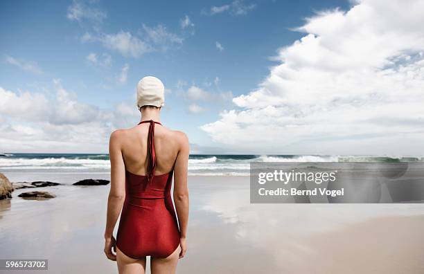 young woman wearing retro swimsuit on beach - traje de baño de una pieza fotografías e imágenes de stock