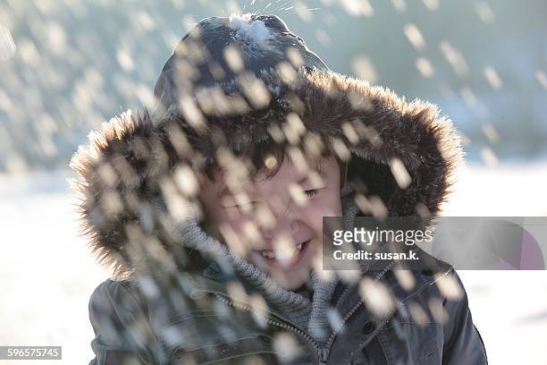boy laughing hard when hit by snowball - boy in hard hat photos et images de collection
