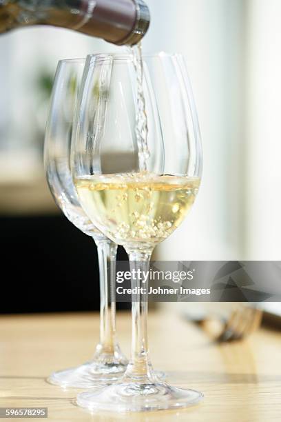 wine is poured into wineglass - witte wijn stockfoto's en -beelden