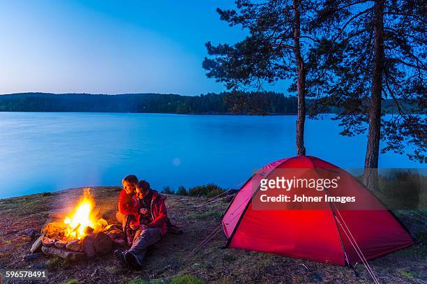 couple camping - haardvuur stockfoto's en -beelden