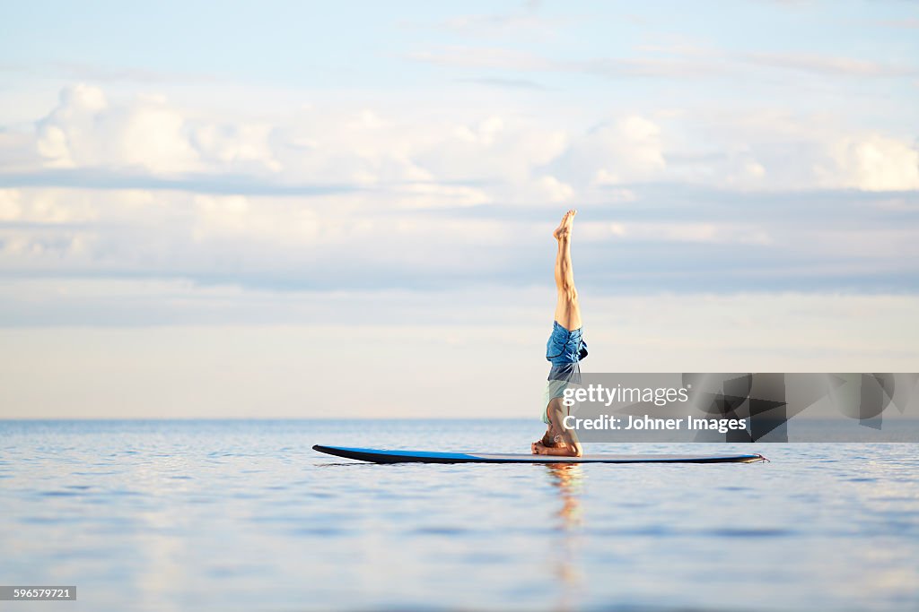 Man doing yoga on paddleboard