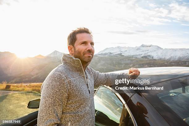 confident man standing next to his car. - guy stubble stock-fotos und bilder