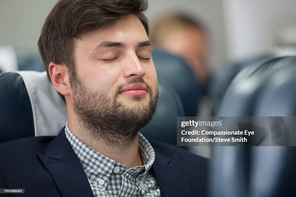 Businessman sleeping on airplane