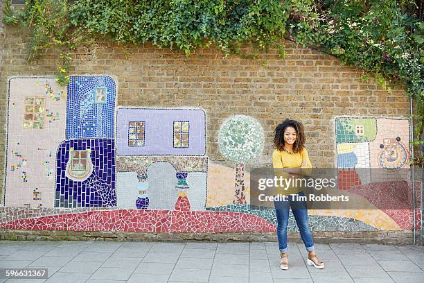 woman stood in front of art wall. - entertainment art and culture stock-fotos und bilder