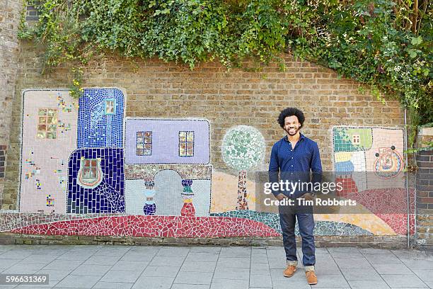 man stood infront of art wall. - afro man stock pictures, royalty-free photos & images