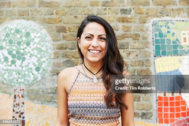 smiling woman in front of mosaic wall. - creative people outside imagens e fotografias de stock