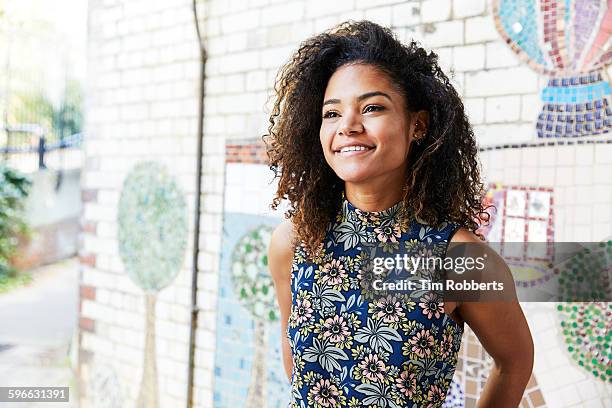 smiling woman next to tiled mosaic wall. - creative people outside imagens e fotografias de stock