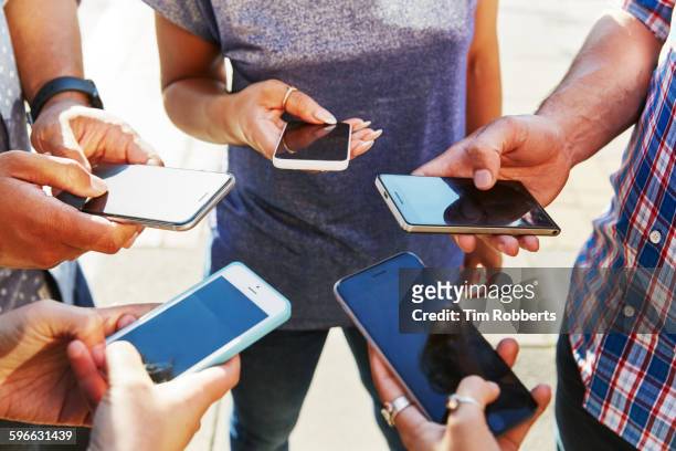 5 friends with smartphones, close up. - manos enlazadas fotografías e imágenes de stock