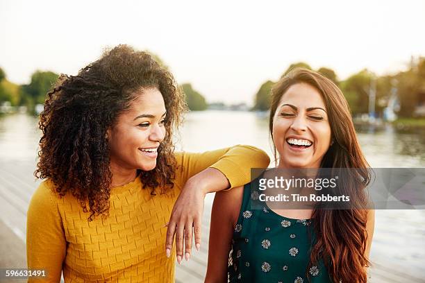 friends laughing next to river. - 20 29 years stock pictures, royalty-free photos & images