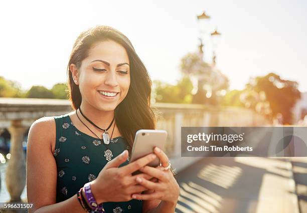 young woman with smartphone on bridge. - indian woman phone stock pictures, royalty-free photos & images