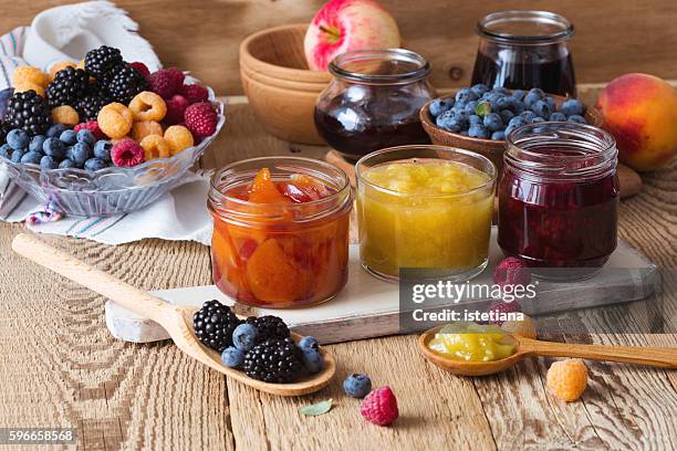 assorted of homemade jam and  ripe fruits and berries on  rustic wooden table. peach, apple, rasberry, blueberry and blackberry confiture in glass jars - チャツネ ストックフォトと画像