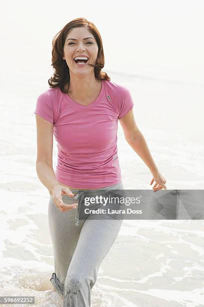 woman walking through surf - laura wade stock pictures, royalty-free photos & images