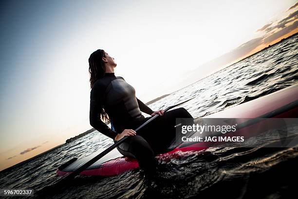 middle aged woman paddle boarding - older woman wet hair stock pictures, royalty-free photos & images