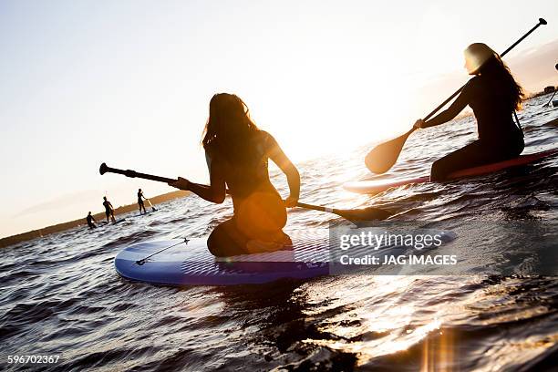 mother and daughter go paddle boarding - paddleboarding stock pictures, royalty-free photos & images