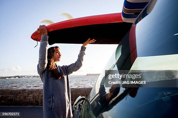 young woman prepares to go paddle boarding - women in see through tops stock pictures, royalty-free photos & images