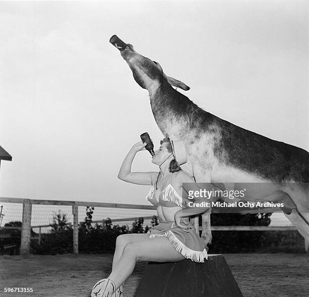 Betty Ames and her donkey Jackson drink from a bottle in Los Angeles,California.